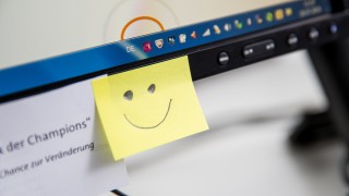 Smiley Post It an einem PC Arbeitsplatz